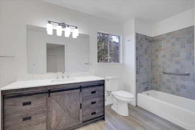 a bathroom with a sink a toilet a large mirror and shower