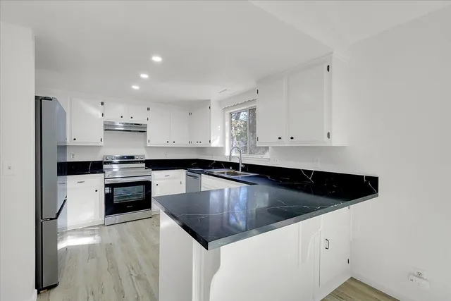 a kitchen with a sink cabinets and stainless steel appliances