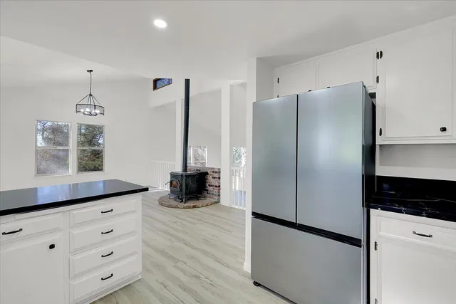 a kitchen with stainless steel appliances a refrigerator and a wooden floor