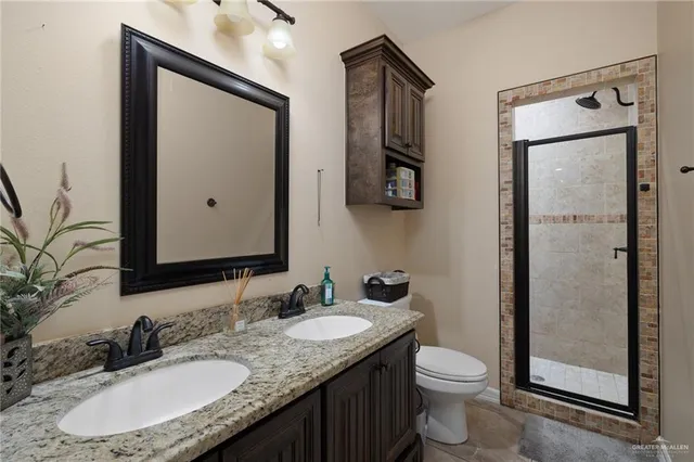 a bathroom with a granite countertop sink toilet and mirror