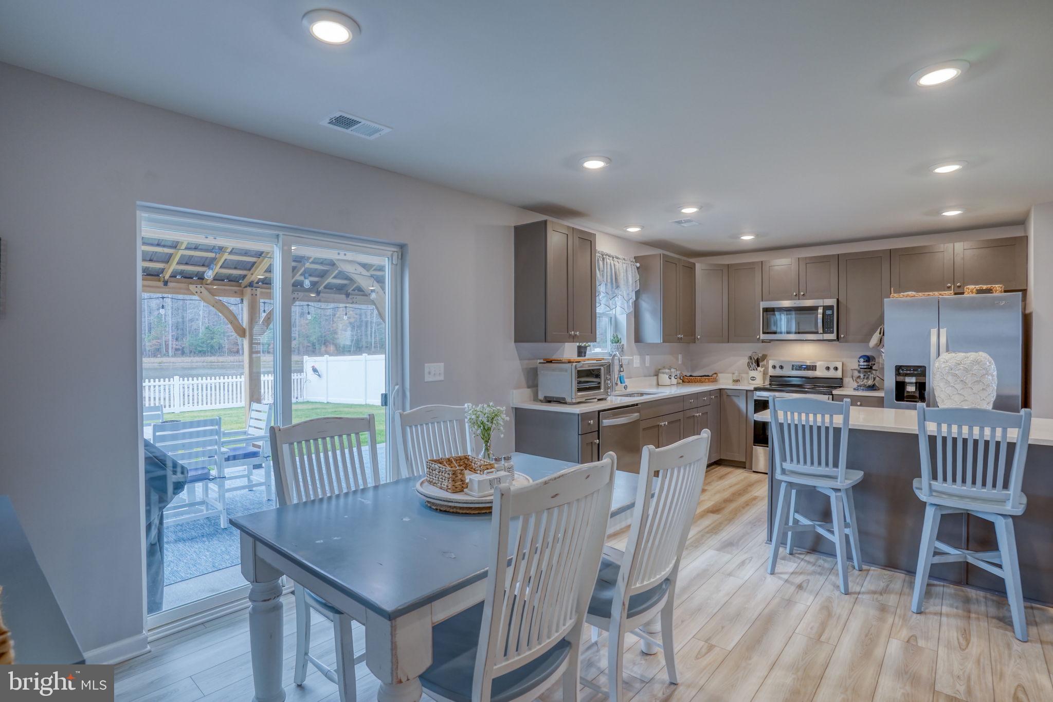653 Cpl Rodney Wayne Wilson Loop Georgetown, DE 19947 - Photo 20 of 55 a kitchen with a dining table chairs and wooden floor