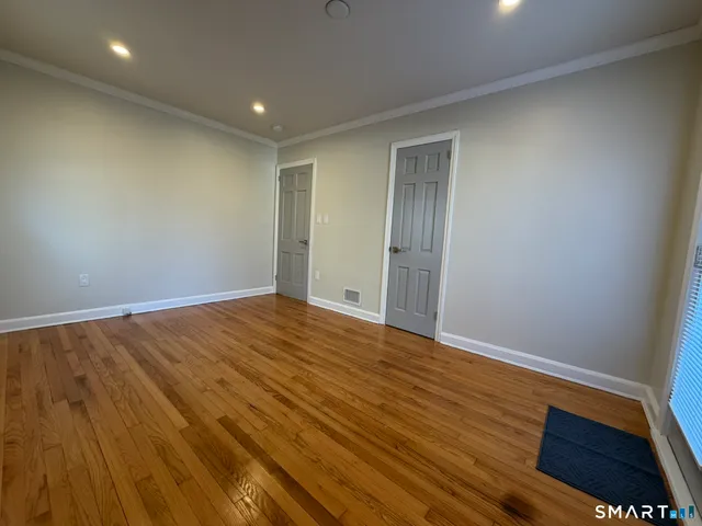 a view of empty room with wooden floor