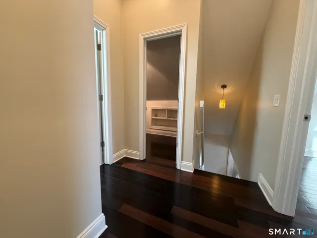 a view of a hallway with wooden floor and staircase