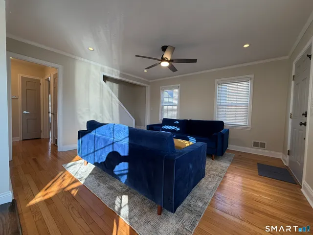 a living room with furniture a ceiling fan and a rug