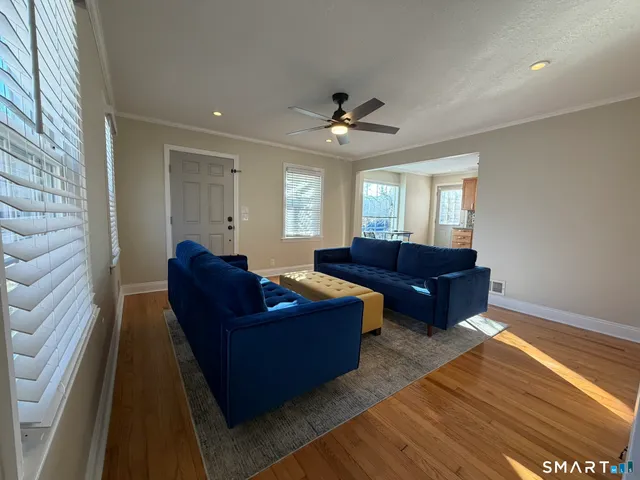 a living room with couches and livingroom view with wooden floor
