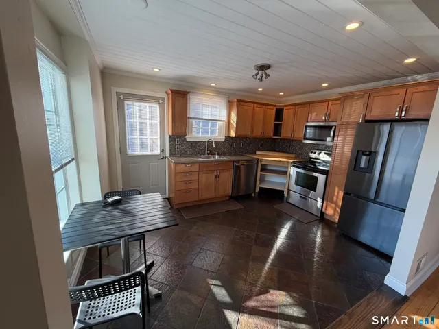 a kitchen with stainless steel appliances granite countertop a stove refrigerator sink and cabinets