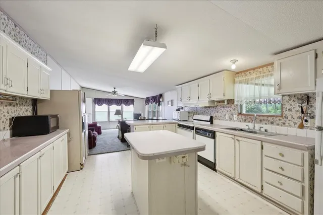 a kitchen with a sink a counter top space stainless steel appliances and cabinets