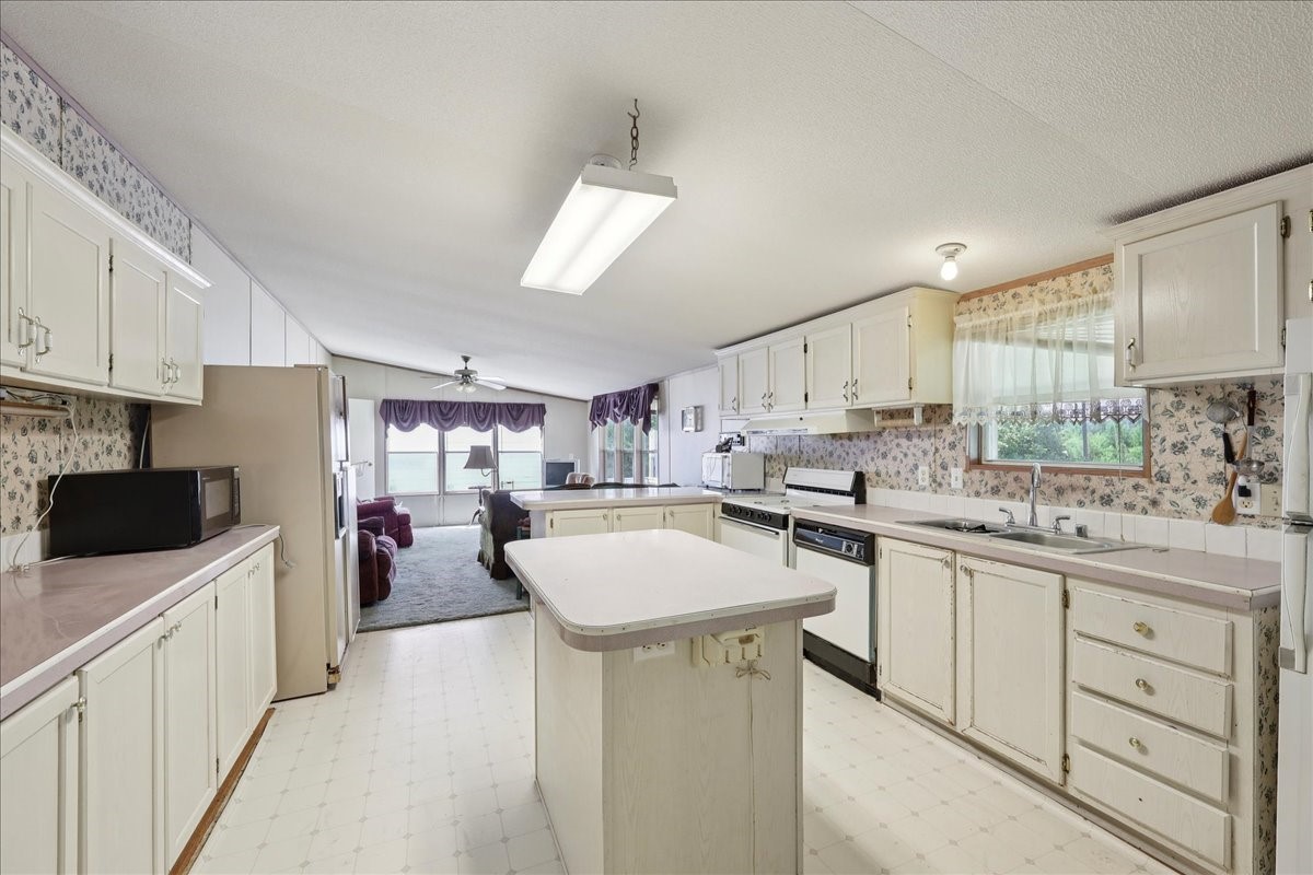 6505 County Road 200 Brookeland, TX 75931 - Photo 17 of 34 a kitchen with a sink a counter top space stainless steel appliances and cabinets