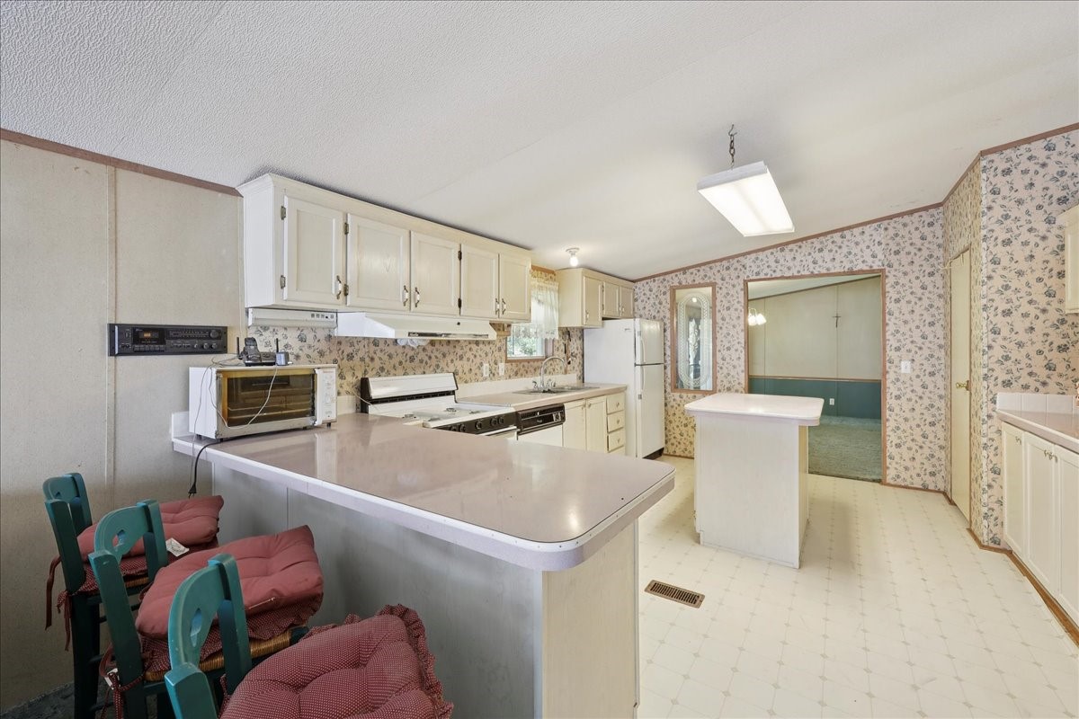 6505 County Road 200 Brookeland, TX 75931 - Photo 20 of 34 a open kitchen with stainless steel appliances white cabinets a sink and a stove
