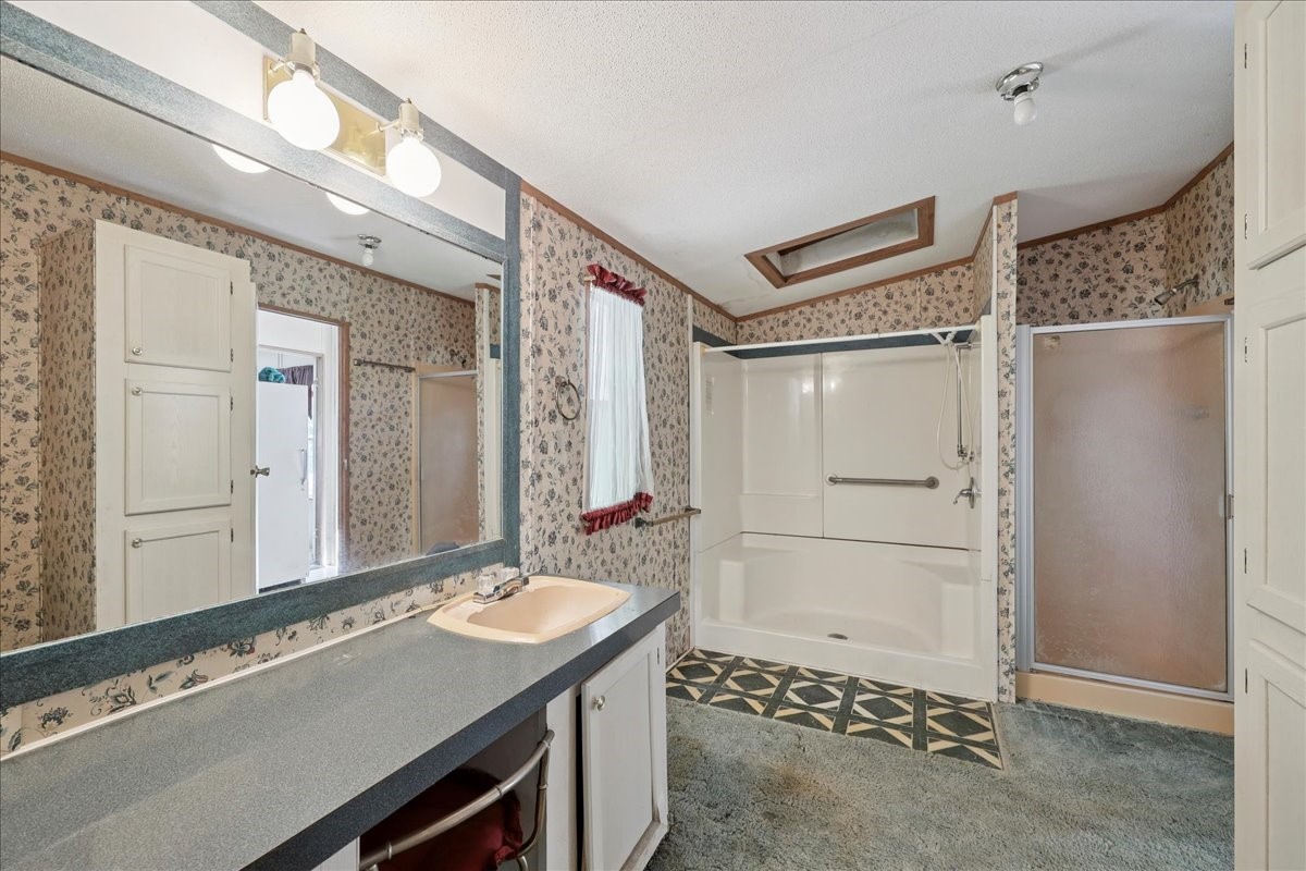 6505 County Road 200 Brookeland, TX 75931 - Photo 24 of 34 a bathroom with a sink a mirror and a shower