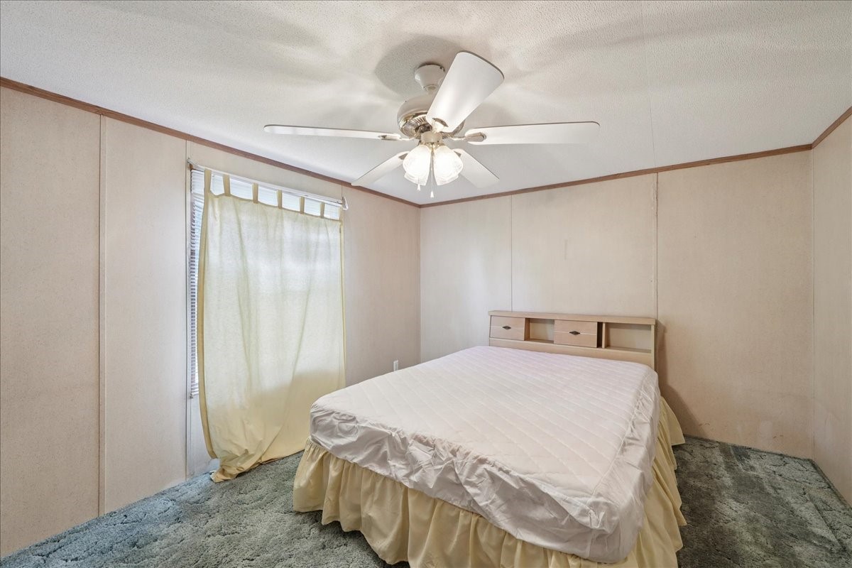 6505 County Road 200 Brookeland, TX 75931 - Photo 26 of 34 a bedroom with a bed and a chandelier fan