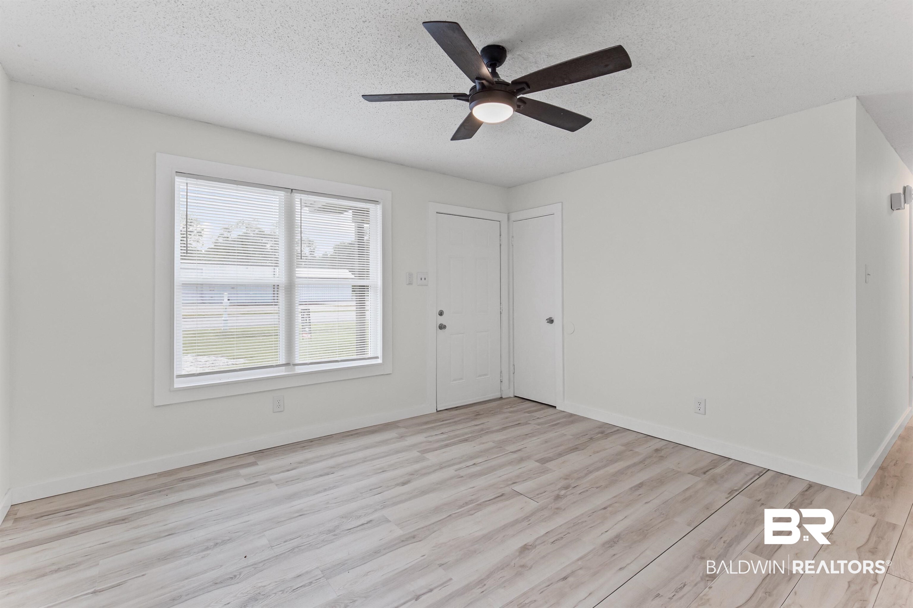 7795 Bellingrath Road Theodore, AL 36582 - Photo 5 of 18 Empty room with a textured ceiling, light wood finished floors, and ceiling fan