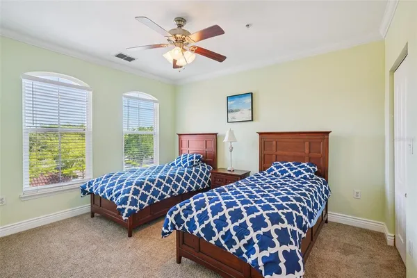 a bedroom with two beds lamp and a large window
