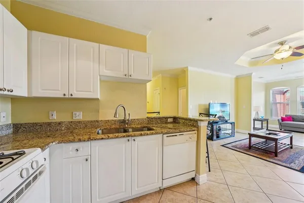 a kitchen with stainless steel appliances granite countertop a stove a sink and a white cabinets