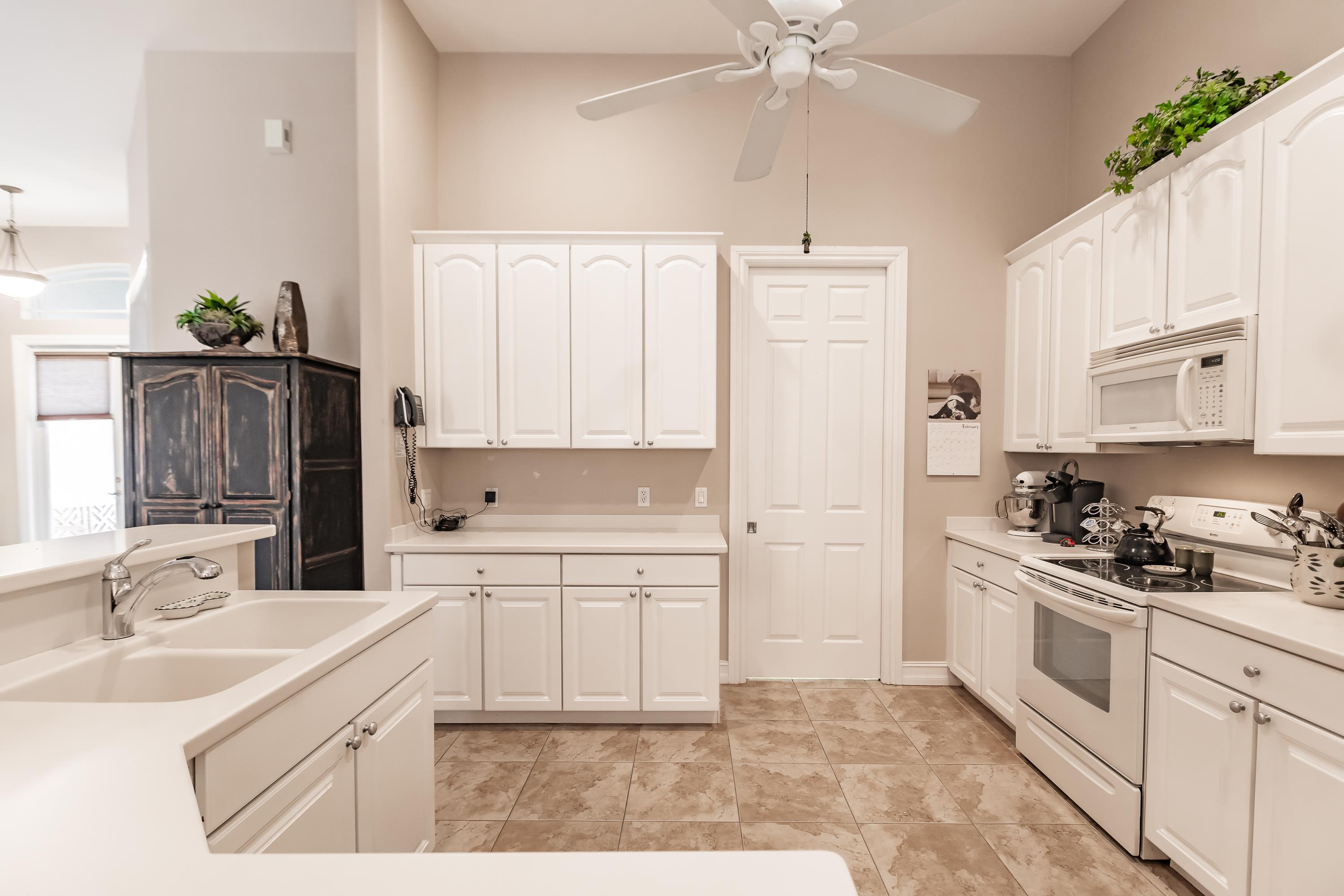 31 Tahiti Road Marco Island, FL 34145 - Photo 12 of 31 a kitchen with white cabinets and appliances