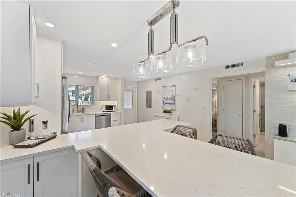 1686 Blue Point Avenue, Unit B5 Naples, FL 34102 - Photo 9 of 46 a large kitchen with kitchen island a sink a counter space and stainless steel appliances