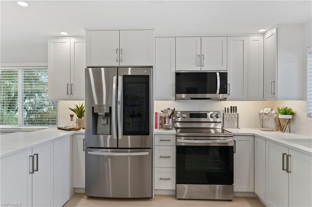 1686 Blue Point Avenue, Unit B5 Naples, FL 34102 - Photo 11 of 46 a kitchen with stainless steel appliances a stove microwave and refrigerator