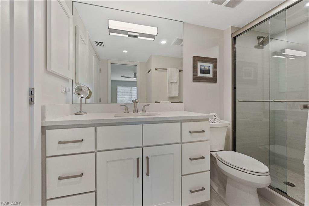 1686 Blue Point Avenue, Unit B5 Naples, FL 34102 - Photo 26 of 46 a bathroom with a toilet a sink a mirror a vanity and shower