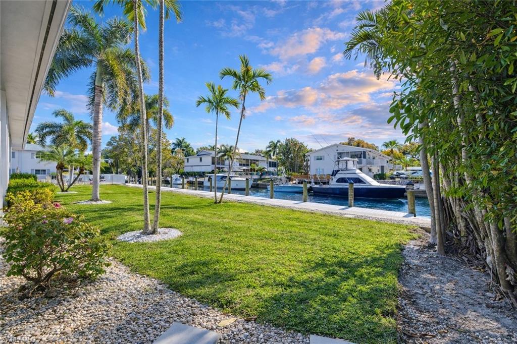 1686 Blue Point Avenue, Unit B5 Naples, FL 34102 - Photo 39 of 46 a swimming pool with lots of tress in front of it