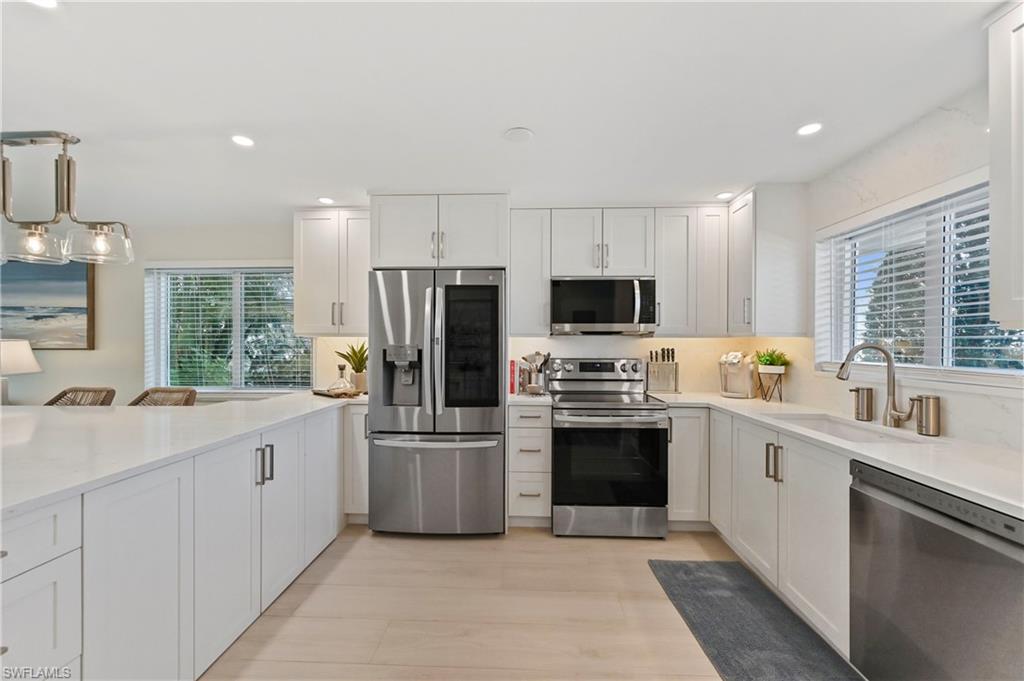 1686 Blue Point Avenue, Unit B5 Naples, FL 34102 - Photo 4 of 46 a kitchen with a sink a stove a refrigerator and white cabinets