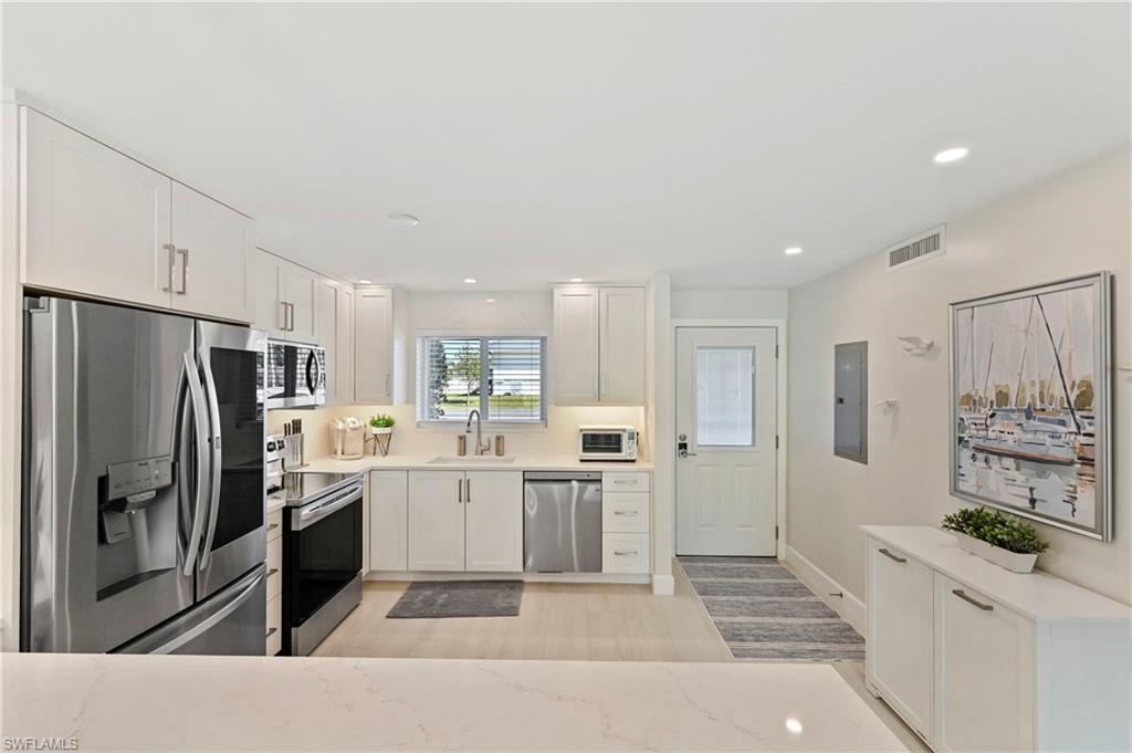 1686 Blue Point Avenue, Unit B5 Naples, FL 34102 - Photo 6 of 46 a kitchen with stainless steel appliances a refrigerator sink and stove