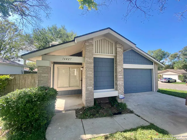 a front view of house with yard and trees around