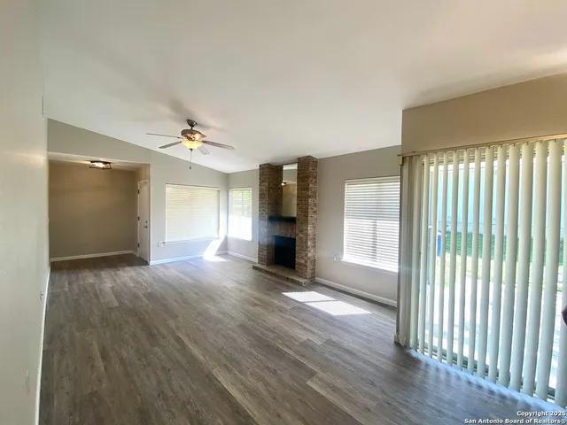 a view of empty room with wooden floor and fireplace