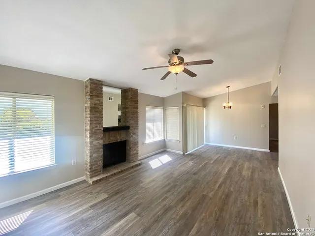 a view of an empty room with a fireplace and a window