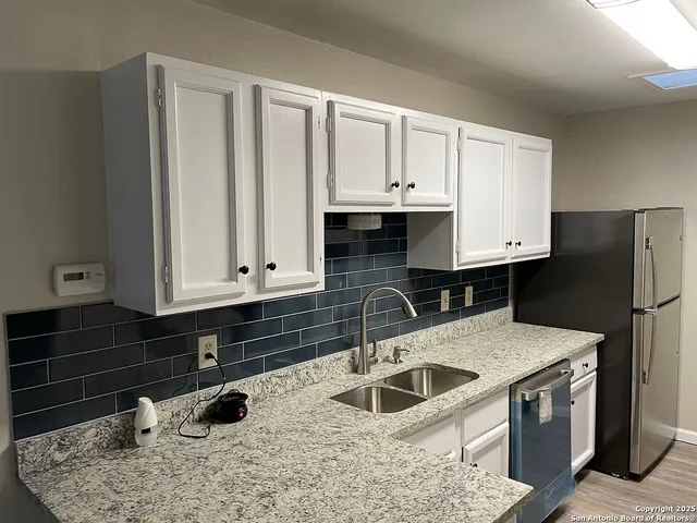 a kitchen with stainless steel appliances a sink a stove and a refrigerator