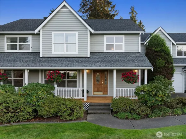 a front view of a house with a yard and potted plants