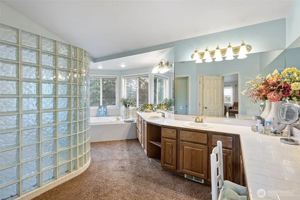 a spacious bathroom with a double vanity sink mirror and a bathtub