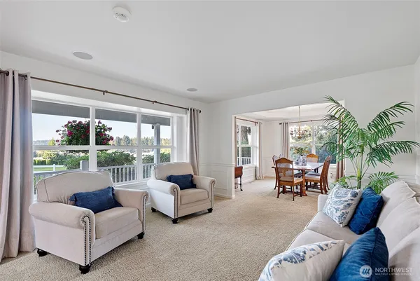 a living room with furniture and a large window with garden view