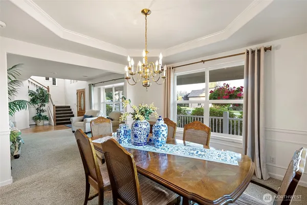 a dining room with furniture a chandelier and window