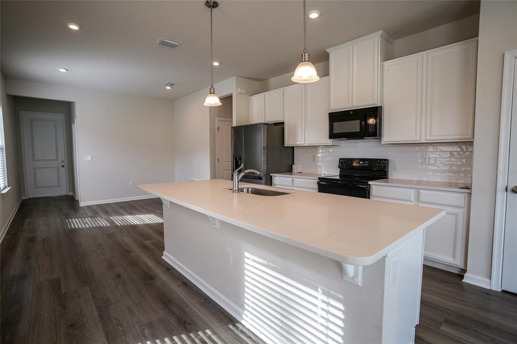 8606 Bonfire Way Parrish, FL 34219 - Photo 2 of 9 a kitchen with a sink a microwave and cabinets