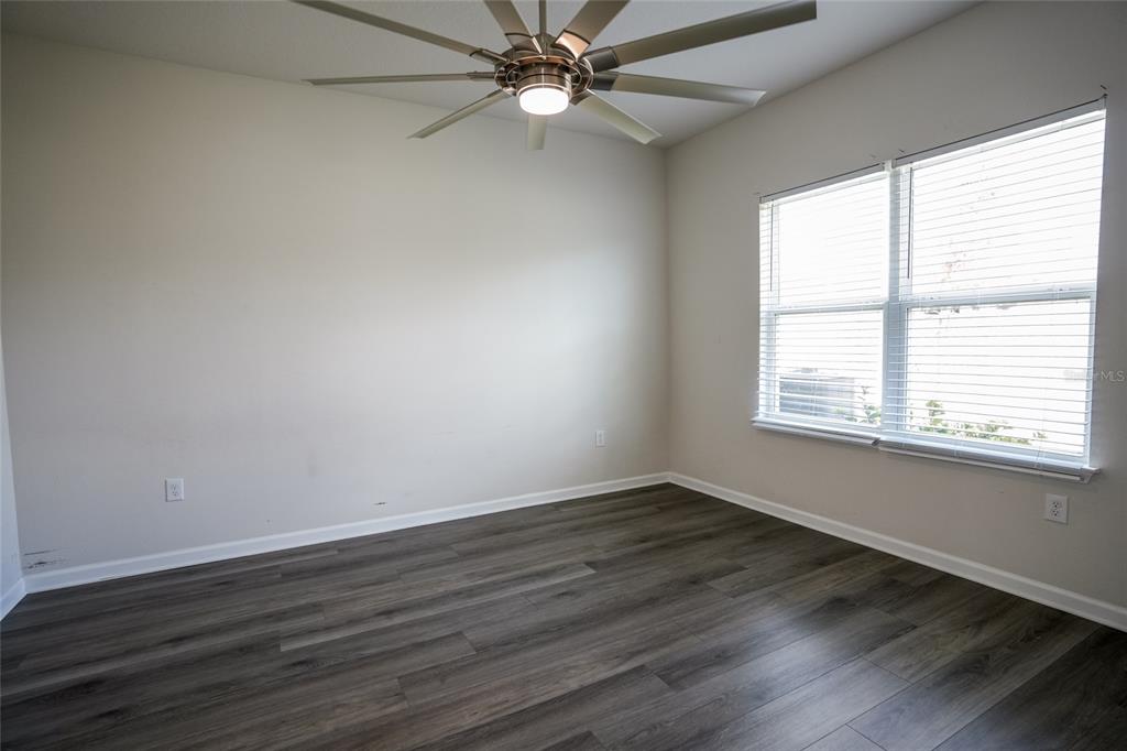 8606 Bonfire Way Parrish, FL 34219 - Photo 4 of 9 a view of an empty room with wooden floor and a window