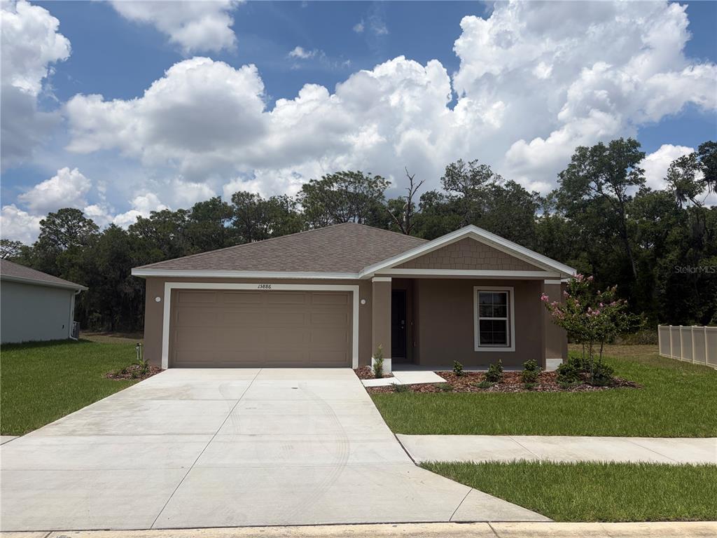15886 Southeast 101st Ct Road Summerfield, FL 34491 - Photo 1 of 14 a front view of a house with a yard and garage