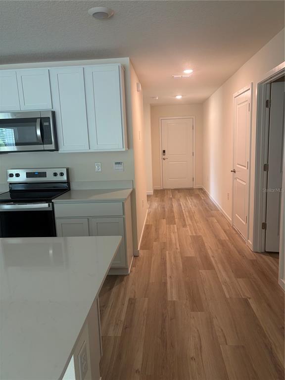 15886 Southeast 101st Ct Road Summerfield, FL 34491 - Photo 2 of 14 a kitchen with wooden floors and appliances