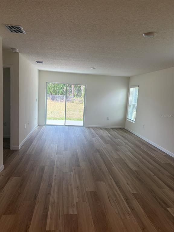 15886 Southeast 101st Ct Road Summerfield, FL 34491 - Photo 5 of 14 wooden floor in an empty room with a window