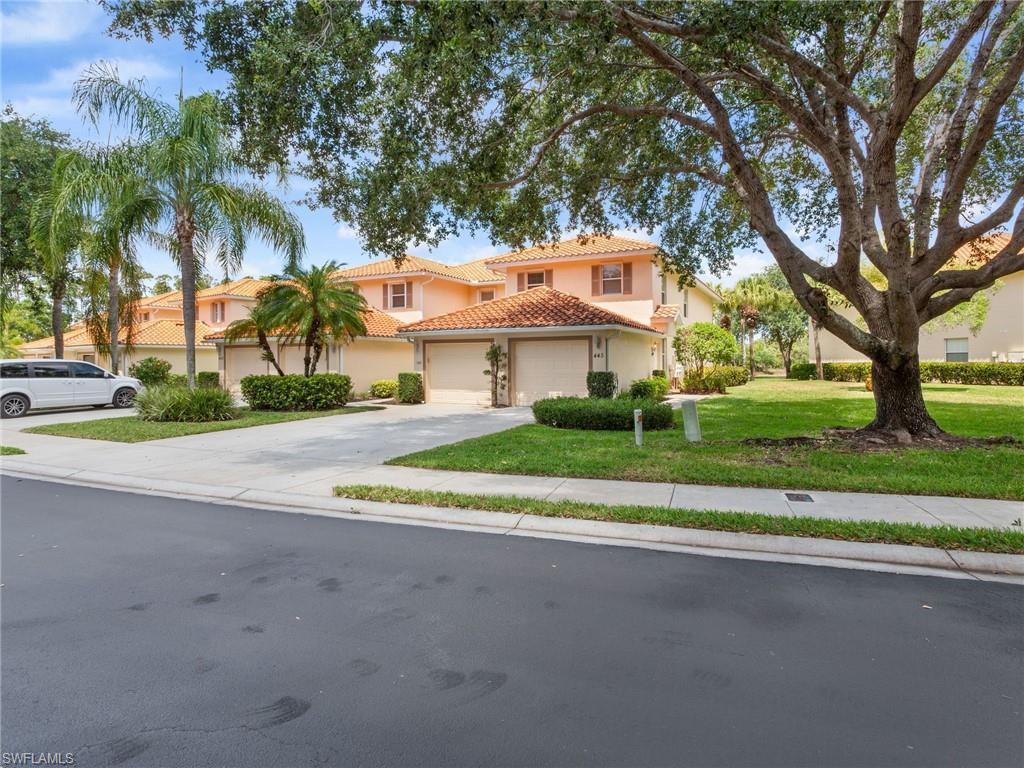 front view of a house with a yard and an trees