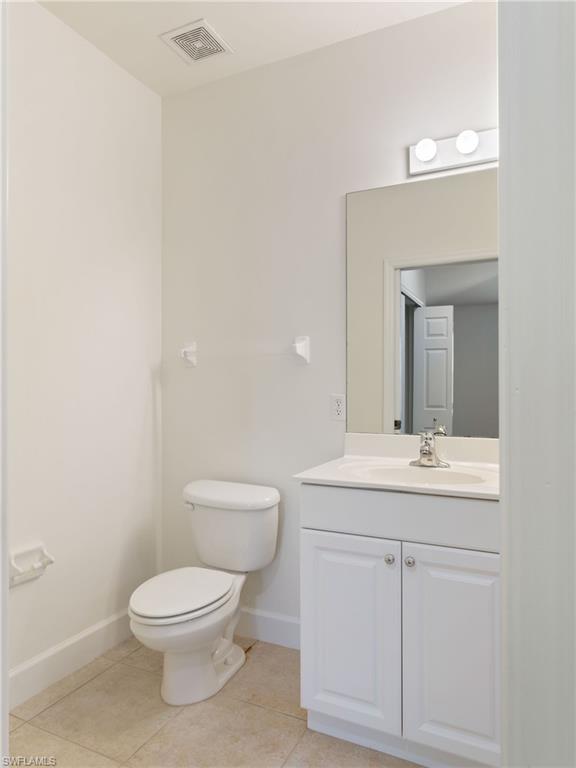 445 Robin Hood Circle, Unit 202 Naples, FL 34104 - Photo 14 of 23 a bathroom with a toilet a sink and mirror