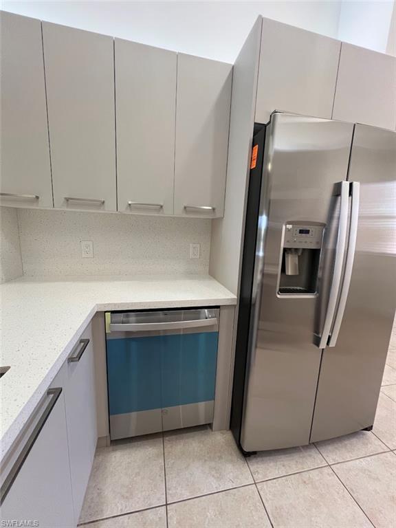 445 Robin Hood Circle, Unit 202 Naples, FL 34104 - Photo 9 of 23 a kitchen with granite countertop a refrigerator and a sink