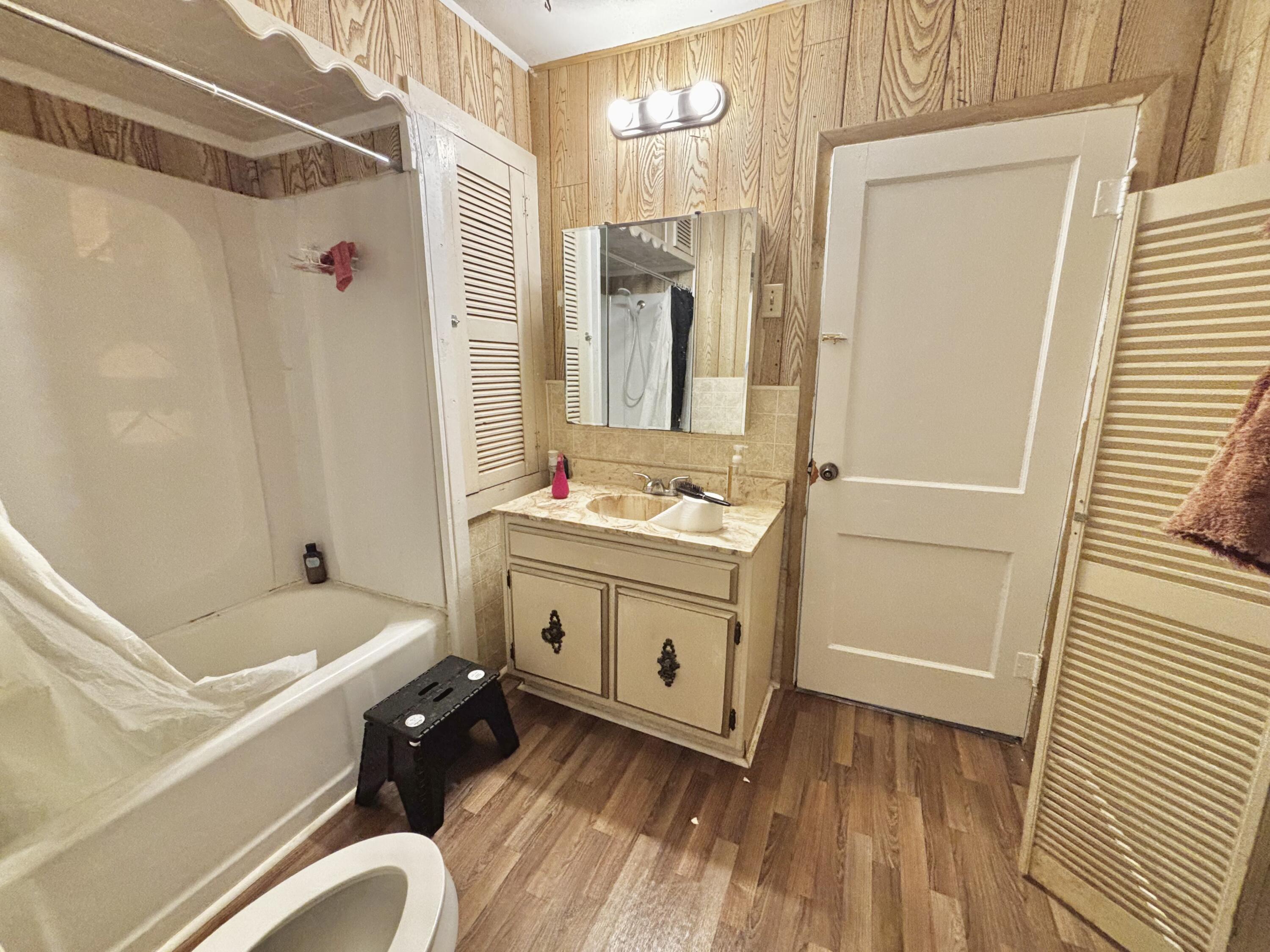 720 South 11th Street Slaton, TX 79364 - Photo 11 of 32 a bathroom with a tub sink and mirror