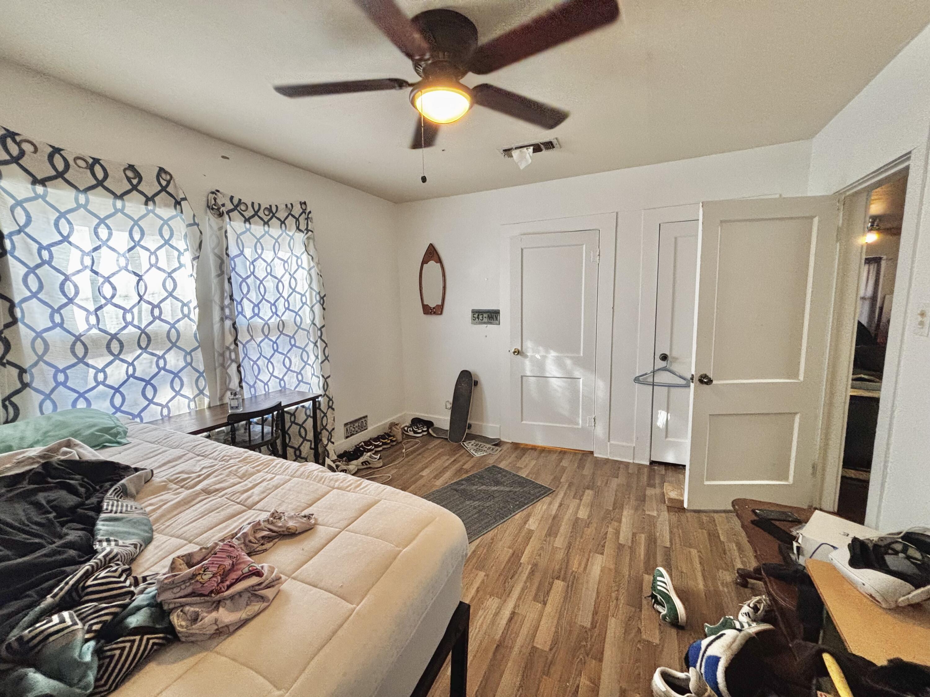 720 South 11th Street Slaton, TX 79364 - Photo 13 of 32 a bedroom with a bed and a chandelier