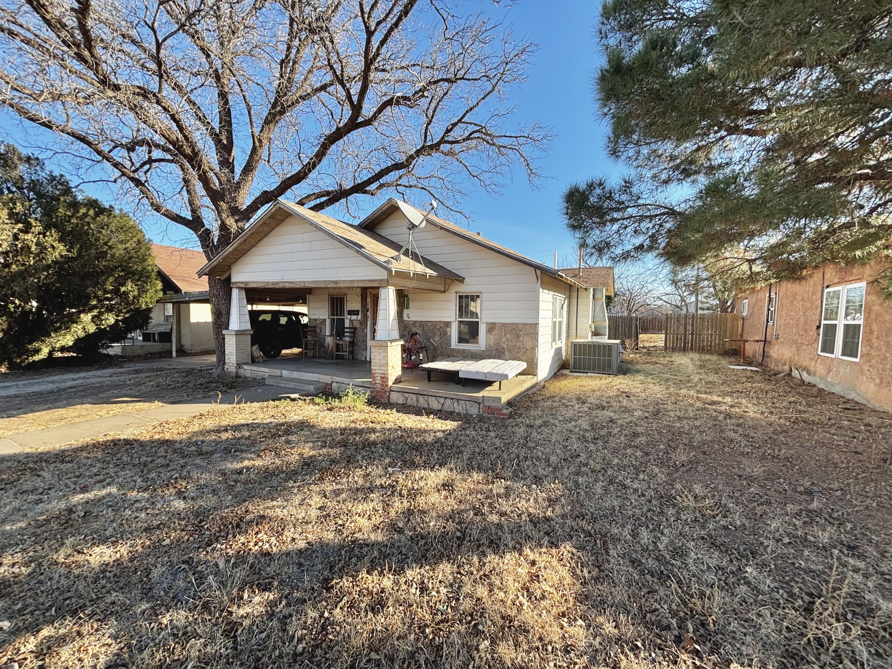 720 South 11th Street Slaton, TX 79364 - Photo 3 of 32 a front view of a house with a yard and large trees