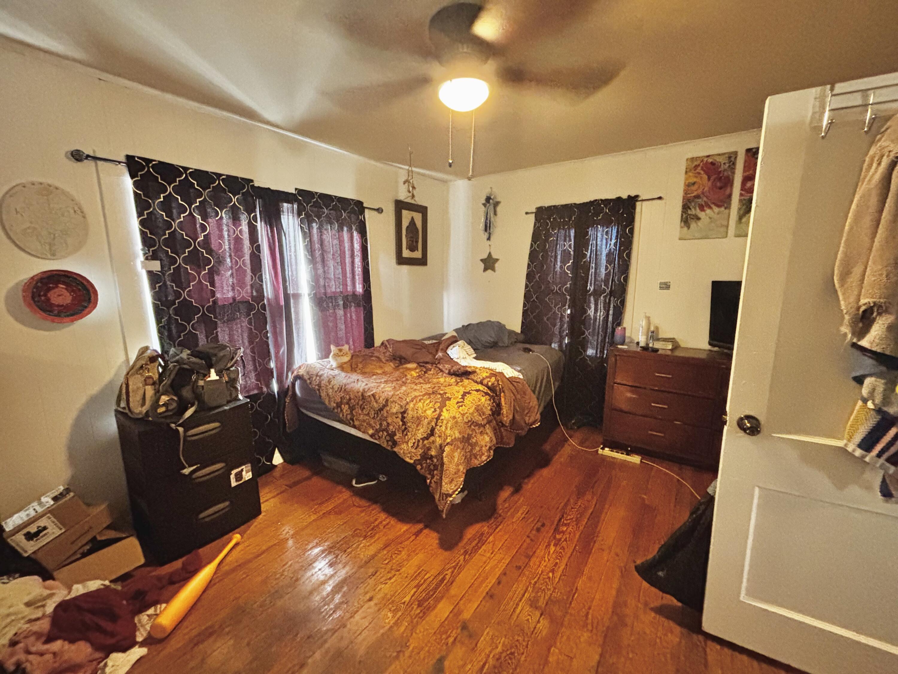 720 South 11th Street Slaton, TX 79364 - Photo 6 of 32 a bedroom with a bed and wooden floor
