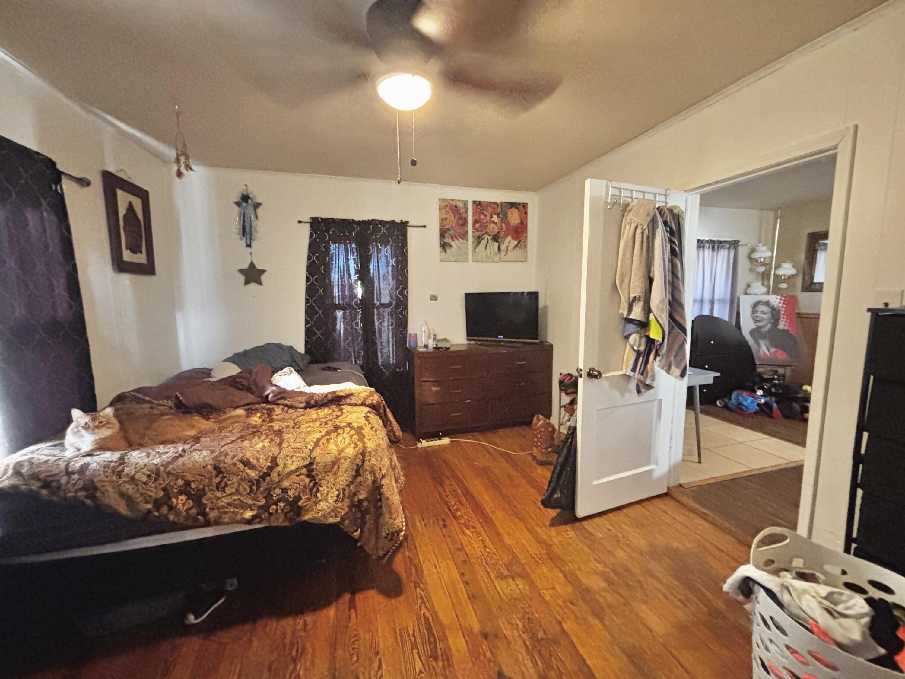 720 South 11th Street Slaton, TX 79364 - Photo 7 of 32 a bedroom with bed and wooden floor