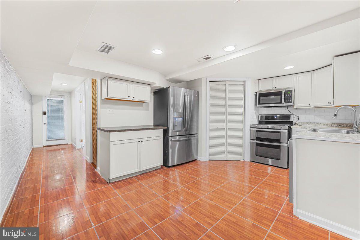 30 R Street Northeast, Unit B Washington, DC 20002 - Photo 11 of 21 a kitchen with granite countertop a refrigerator and a stove top oven