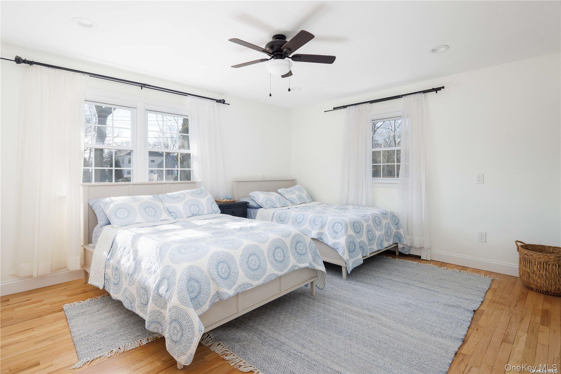 129 Lynncliff Road Hampton Bays, NY 11946 - Photo 11 of 19 a spacious bedroom with two beds and a chandelier