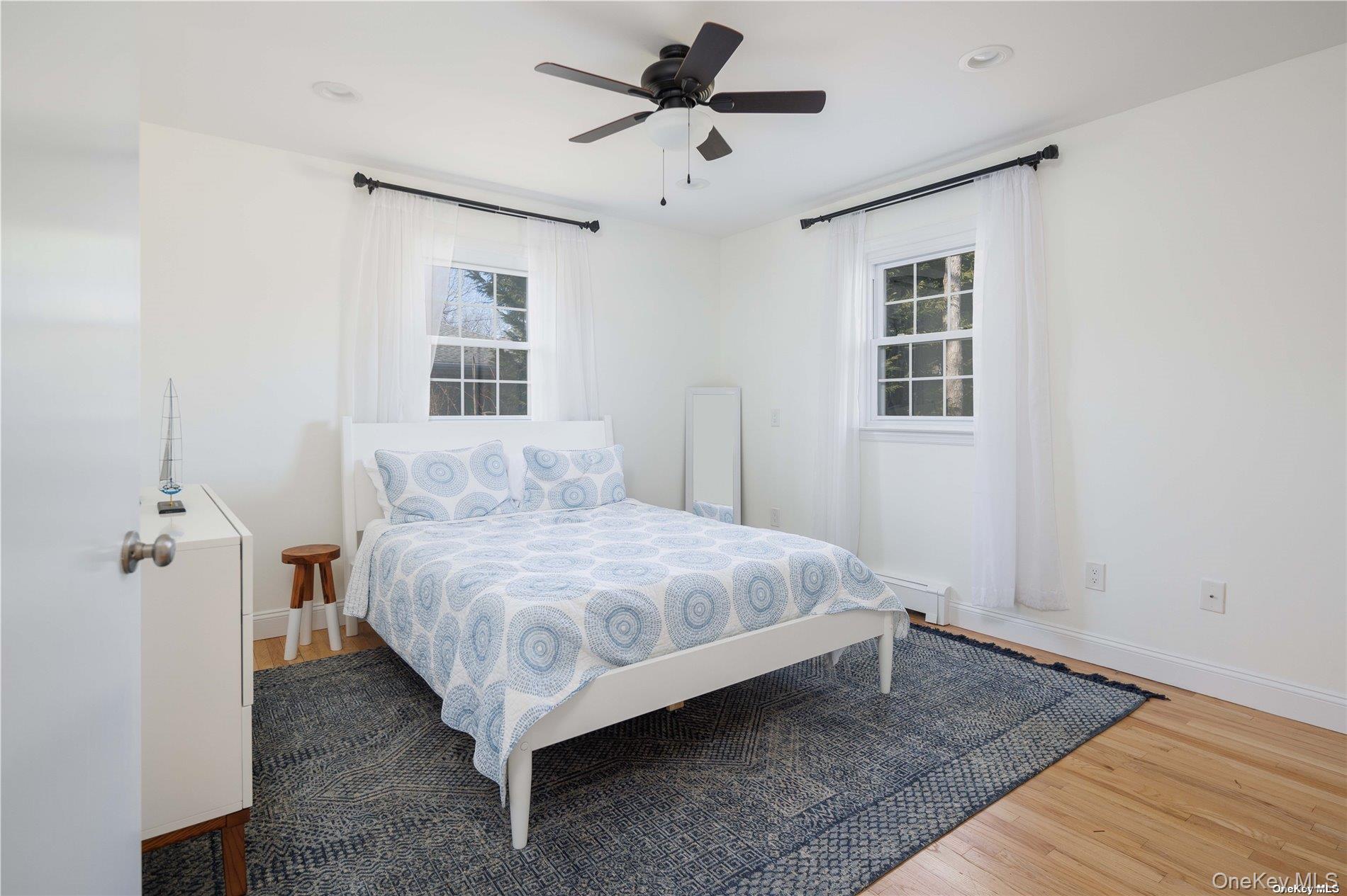 129 Lynncliff Road Hampton Bays, NY 11946 - Photo 14 of 19 a spacious bedroom with a bed and a window