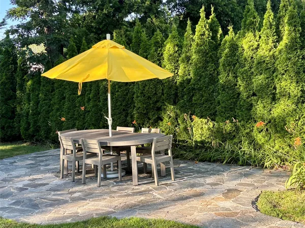 a view of backyard with table and chairs under an umbrella